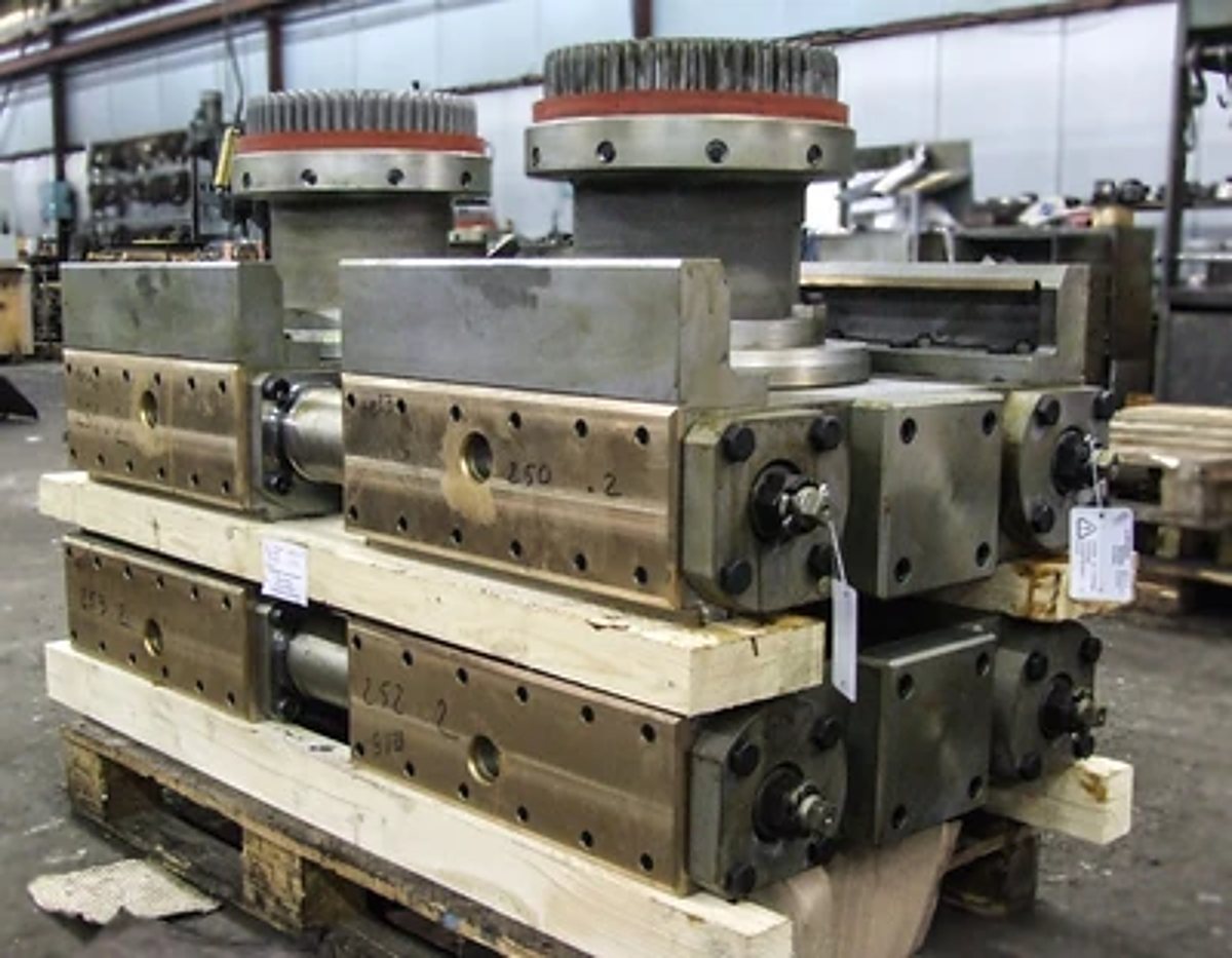 Blocs mécaniques industriels posés sur une palette en bois dans un atelier
