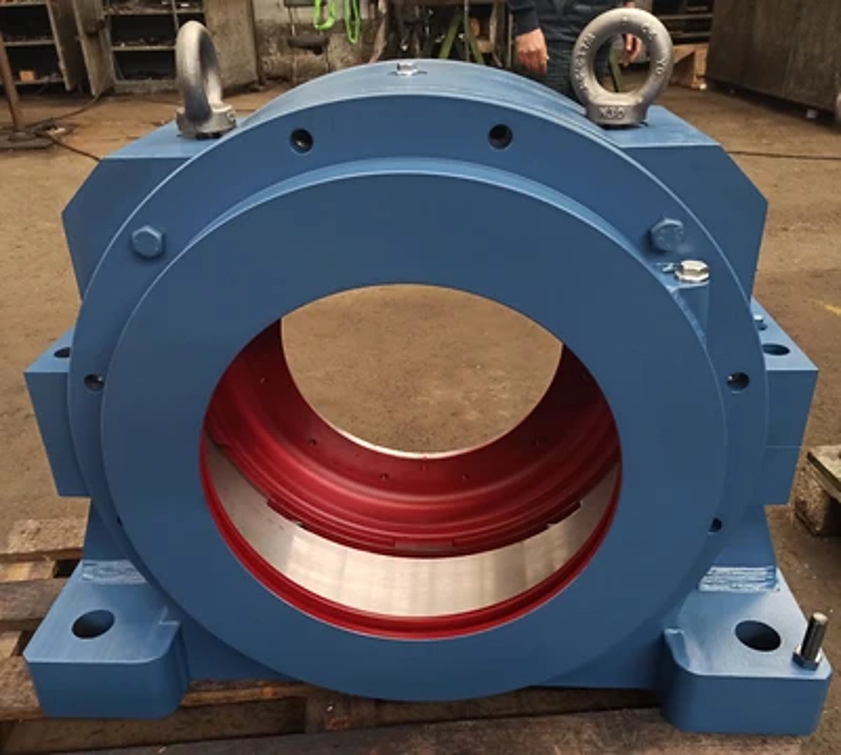 Grand palier industriel bleu à intérieur rouge posé sur une palette en atelier