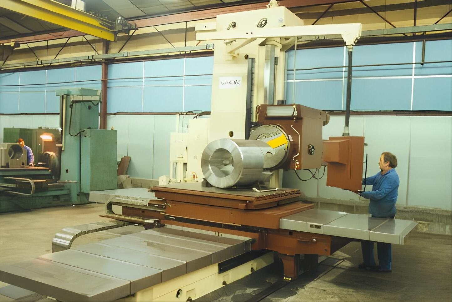 Opérateur devant une grande aléseuse industrielle dans l’atelier