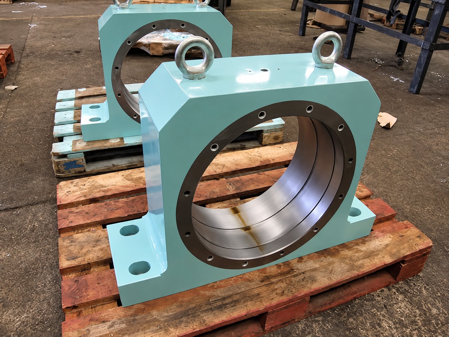 Deux gros paliers industriels peints en vert clair sur palettes en bois