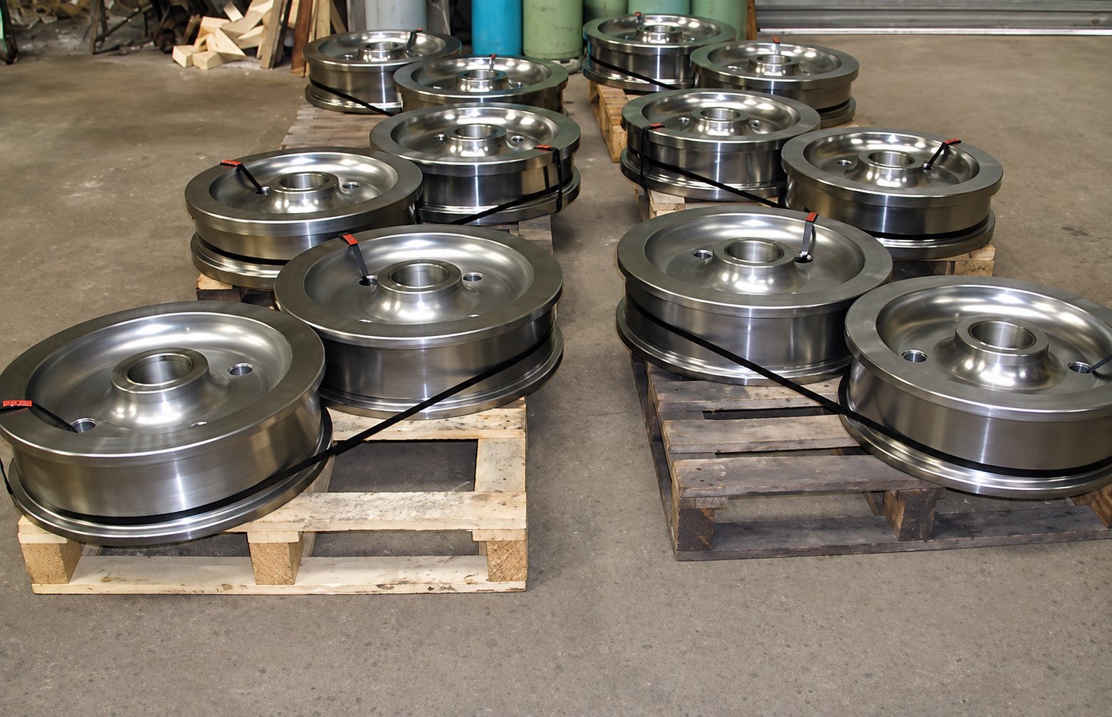 Roues de grue métalliques posées sur des palettes en bois dans un atelier